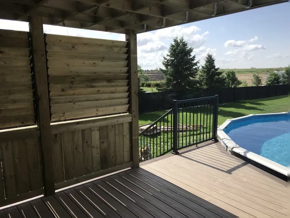 photo of the "Rossmore" deck, a composite deck around a raised swimming pool designed and built by KMA Building in Winnipeg, MB